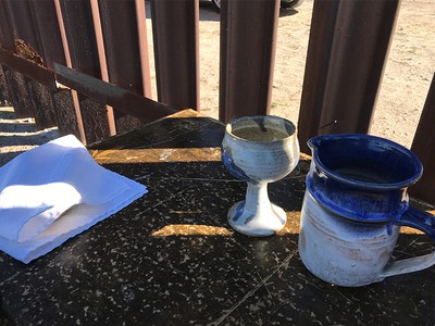 Image of communion ware set up at the border wall in Texas.