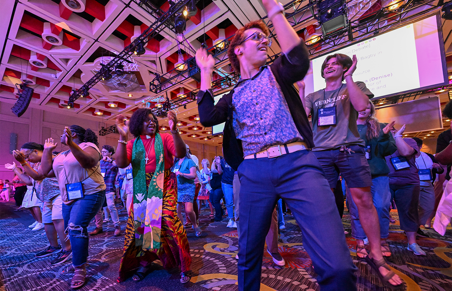 The Rev. CeCe Armstrong, co-moderator of the 226th General Assembly and Commissioner Dustin Wilsor join commissioners and advisory delegates in a dance break during Tuesday night’s plenary at the 226th General Assembly. Photo by Rich Copley