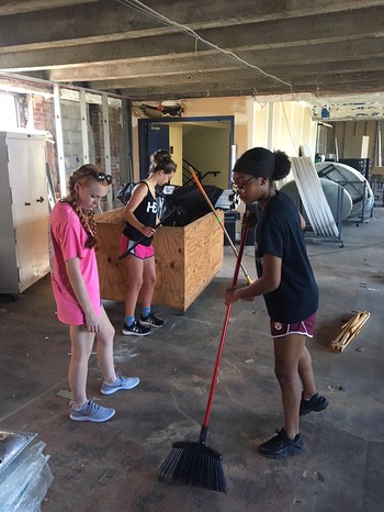 Young volunteers help clean up a work site as part of their Hands and Feet experience at Amen House in St. Louis. 