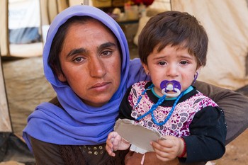 A Yazidi woman and her young daughter narrowly escaped ISIS forces. They, along with her husband Guly Badal Jerdo and other children, found refuge in one of many internally displaced persons (IDP) camp locations in Khanke, Iraq. (Aug. 29, 2014) 