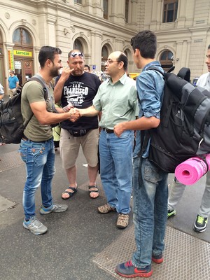 Amgad Beblawi talks with young men from Syria about their train tickets.