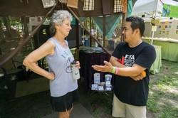 Susan Presson of Grace Covenant Presbyterian Church in Asheville, N.C., speaks with PC(USA) moderator of the 218th General Assembly (2008) Bruce Reyes Chow at the Presbyterian Hospitality tent at the Wild Goose Festival in Hot Springs, N.C.