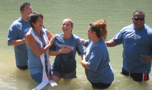 A woman is baptized by other people.