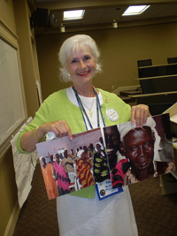 A woman holding images of Sudanese people.