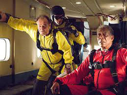 Two three men in red and yellow jumpsuits, preparing to jump from a plane. (From the movie, "The Bucket List.")