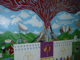 A mural painted with a volcano erupting among green mountains into a blue sky; a banner is beneath it.