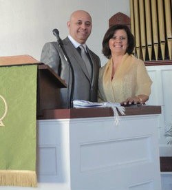 Rev. Paulo Lima with wife Zilda behind church pulpit