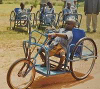 A young Nigerian afflicted with polio is given a free hand-cranked bicycle/wheelchair he can ride to school.