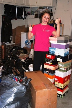 Girl standing with shoe boxes and shoes