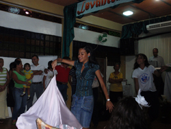 A  woman twirls a white sheet in the middle of a crowd