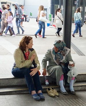 Michelle Lori meeting with a Syrian woman resting on the curb at the Keleti train station in Budapest. 