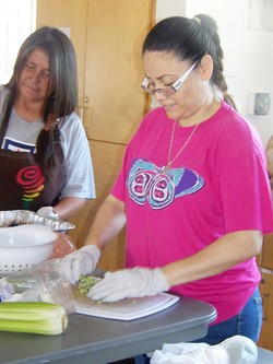 Rosa Robles Loreto (right), with Ana Bitsoie, chops vegetables for Cross Streets Community, a program of free meals and showers at Southside Presbyterian Church.