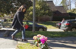 A woman places flowers near a building where three young Muslims were killed on Tuesday, in Chapel Hill, North Carolina on February 11, 2015.