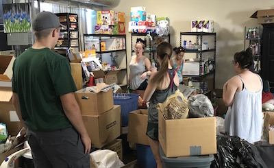 Students from UKirk at Michigan State University sort through donations to the International Institute of St. Louis as part of their “Hands and Feet” experience.