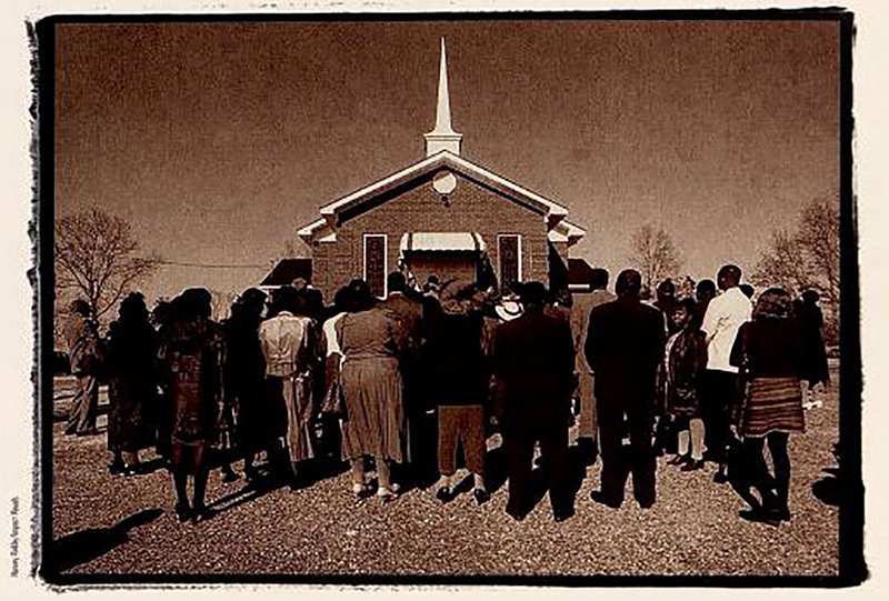 Members gathered around a rebuilt church. Photo taken from the Burned Churches Project report 