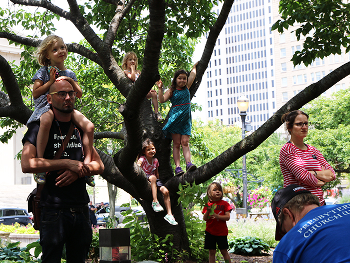Those attending the End Cash Bail rally sought shade, and a vantage point, wherever they could find it.(Photo by Angie Stevens