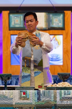 Moderator Neal Presa breaks the communion bread at Opening Worship at the 221st General Assembly of the PC(USA) in Detroit, MI on Saturday, June 14, 2014.