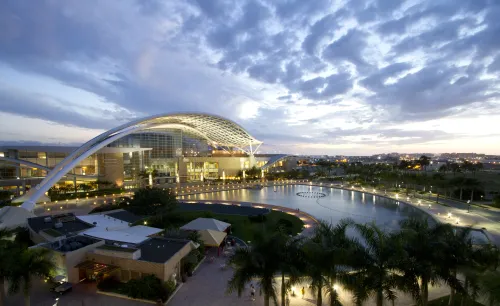 The Puerto Rico Convention Center with its swooping roof lit up under a cloudy twilight sky.