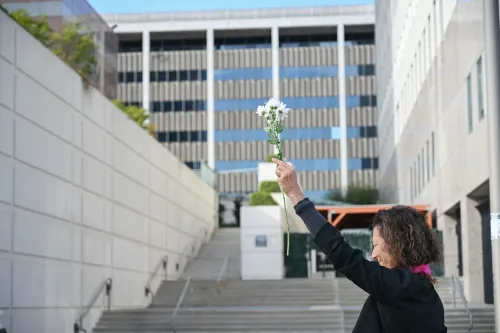 A flower held in the air above a federal detention centre.