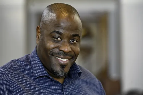 Headshot of smiling man in blue shirt