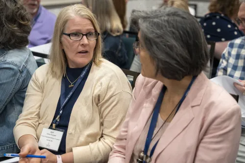 Two women speak during a conference breakout session.