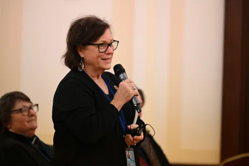 A woman speaks at a microphone