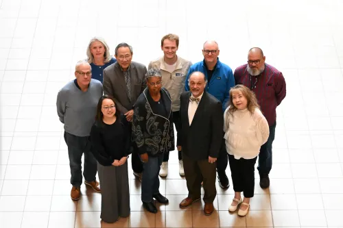 A group of people photographed from above with a brightly lit floor behind them.