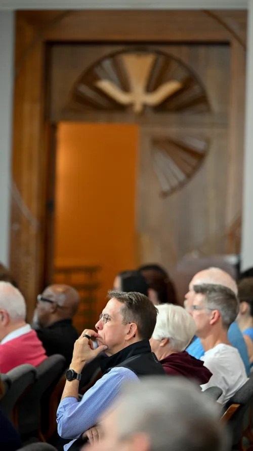 A man in contemplation with his eyes closed in a chapel.