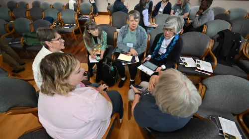 A group of people sit in a circle talking.