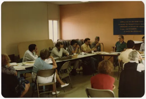 A group of people sit at two conference tables at the First More Light Churches Conf. held at West Hollywood Presbyterian Church in May 1985.