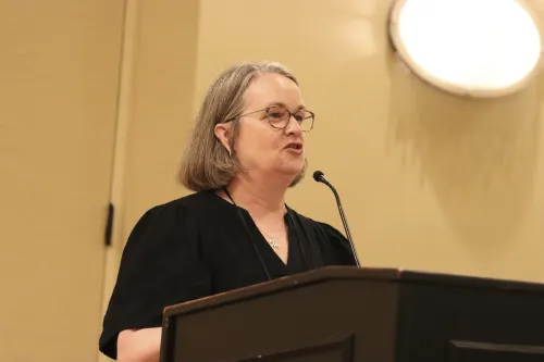 A woman speaks at a lectern in a meeting room