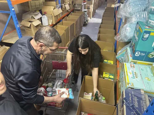 A woman and a man lingering over boxes of humanitarian supplies