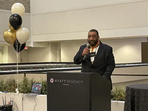 Rev. Gregory J. Bentley speaking behind podium atGA227