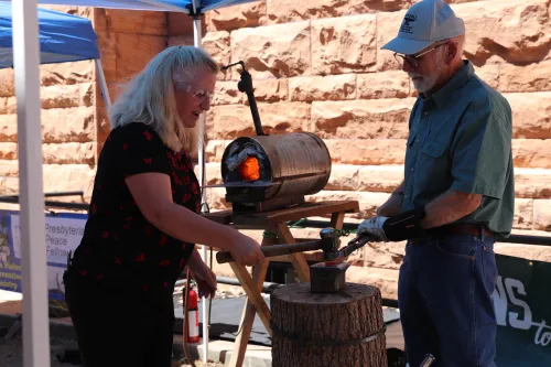 a woman and a man use machinery to turn a gun into a garden tool