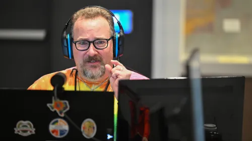 Person wearing headphones gazes at two screens