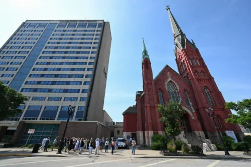 tall building on left next to church on right
