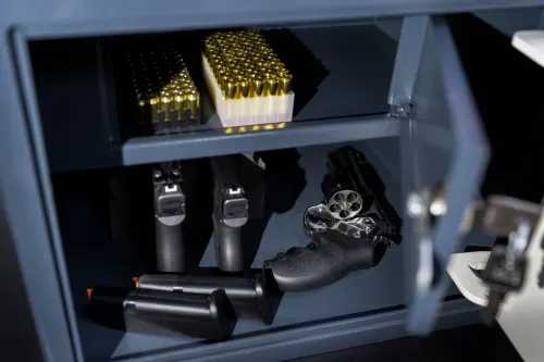 a gray gun safe holds brass bullets and several revolvers 