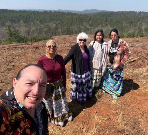 Residents of Maskoke eco-village on top of hill after mulching