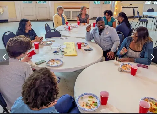 Voices of Jubilee volunteers gather at table to reflect on their ministry of accompaniment.