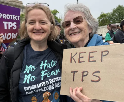 Two women holding a Keep TPS sign
