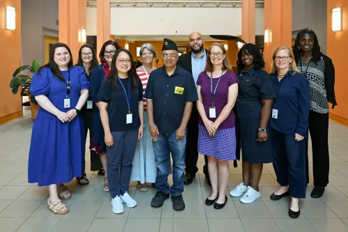 A group of women and men pose for a picture in a lobby
