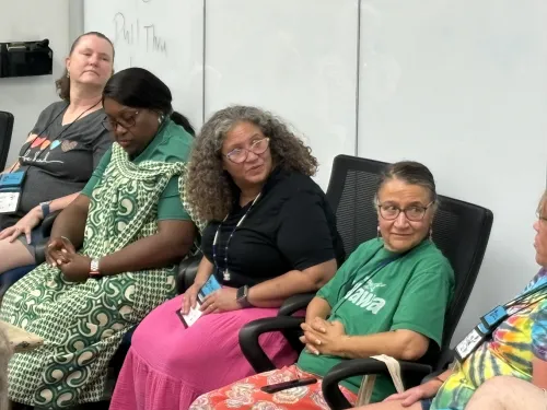 Three women participate in what appears to be a casual conversation. 