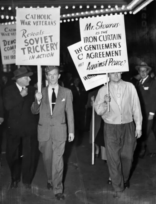 Men in suits with pickets at an anti-Soviet movie in 1948.