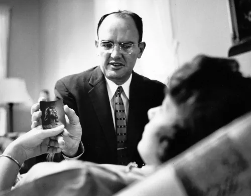 A minister in Georgia promoted hypnotism as a part of pastoral counseling. Here he offers a patient a picture of Jesus Christ.
