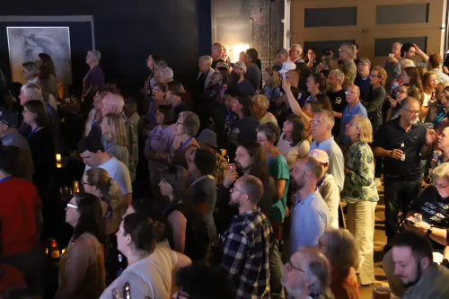 People sing along in a crowded bar