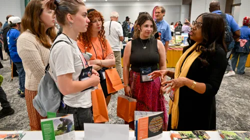 Woman interacts with a group of young people at an event