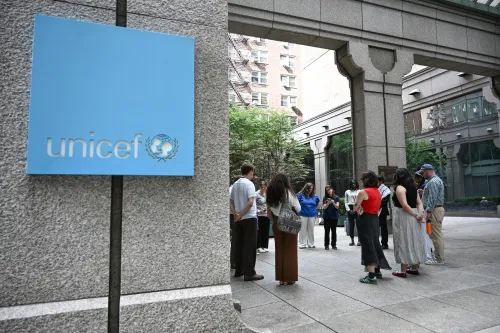 Next to the unicef building, a group of young adults pray in a circle.