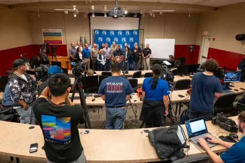 People gathered to discuss wildfires with camera persons pointed in their direction