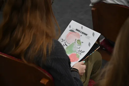 A young adult prepares her paper for the fruits of the spirit exercise. 