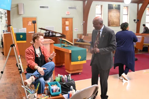 Worship co-artist Jeff McAllister greets a member of Hillside Presbyterian Church during worship as the rest of the congregation passes the peace of Christ. 